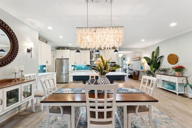 dining space with crown molding, light wood-style flooring, a chandelier, recessed lighting, and baseboards