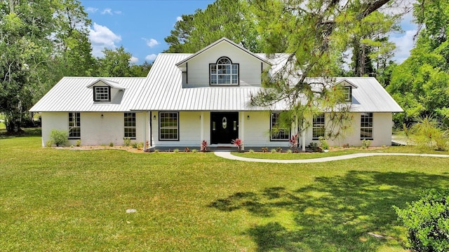 view of front facade with covered porch, metal roof, a front lawn, and brick siding