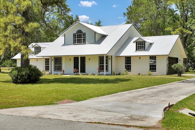 view of front of house with covered porch, metal roof, brick siding, and a front yard