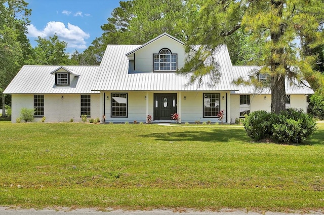 view of front of home with covered porch, metal roof, brick siding, and a front lawn