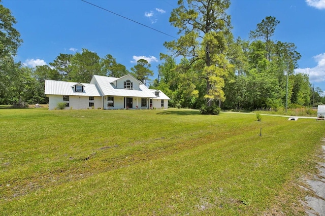 view of front facade with covered porch, metal roof, and a front lawn
