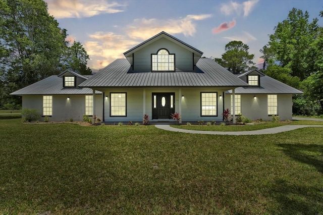 view of front of home featuring a yard, metal roof, and covered porch