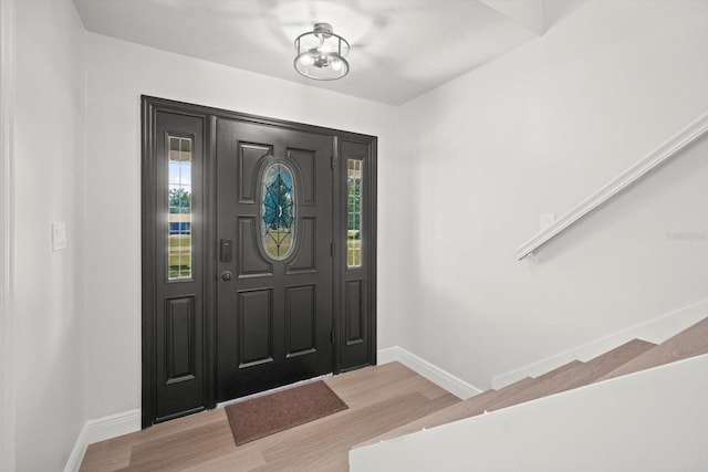 entrance foyer featuring light wood-style flooring, baseboards, and a healthy amount of sunlight