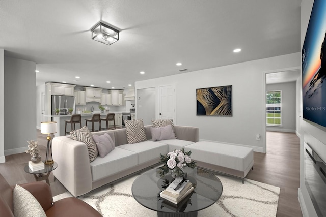 living room featuring light wood-style flooring, baseboards, visible vents, and recessed lighting