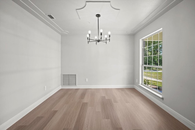 unfurnished dining area with a chandelier, a wealth of natural light, visible vents, and light wood finished floors