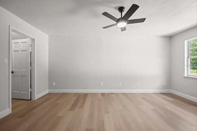 spare room featuring baseboards, light wood-style flooring, and a ceiling fan