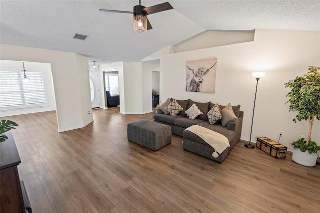 49 Louisiana Dr, Palm Coast, FL 32137 - living room with a ceiling fan, wood finished floors, vaulted ceiling, baseboards, and a textured ceiling