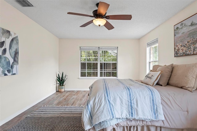 49 Louisiana Dr, Palm Coast, FL 32137 - bedroom with wood finished floors, a textured ceiling, baseboards, and ceiling fan