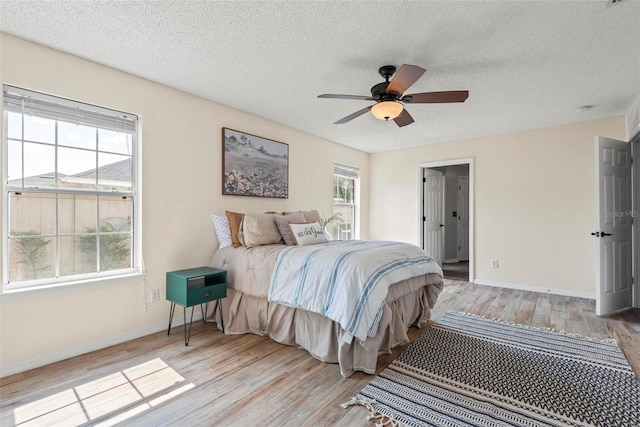 49 Louisiana Dr, Palm Coast, FL 32137 - bedroom featuring light wood-style floors, a textured ceiling, baseboards, and ceiling fan
