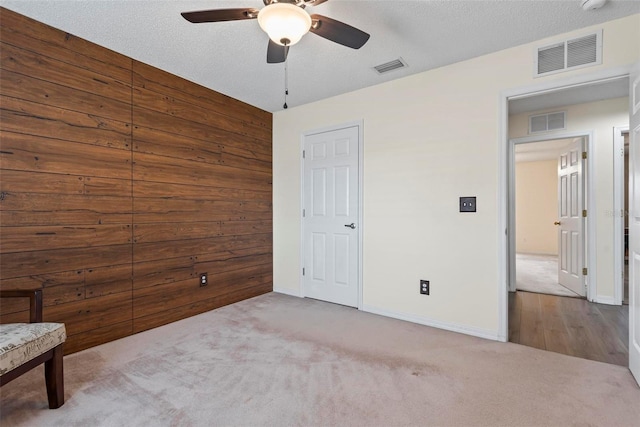 49 Louisiana Dr, Palm Coast, FL 32137 - unfurnished bedroom featuring carpet flooring, baseboards, wooden walls, and ceiling fan
