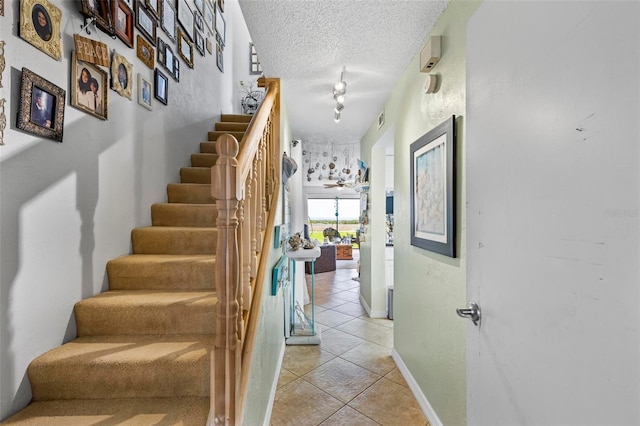1601 N Ocean Shore Blvd, Flagler Beach, FL 32136 - stairway featuring tile patterned flooring, a textured ceiling, and baseboards
