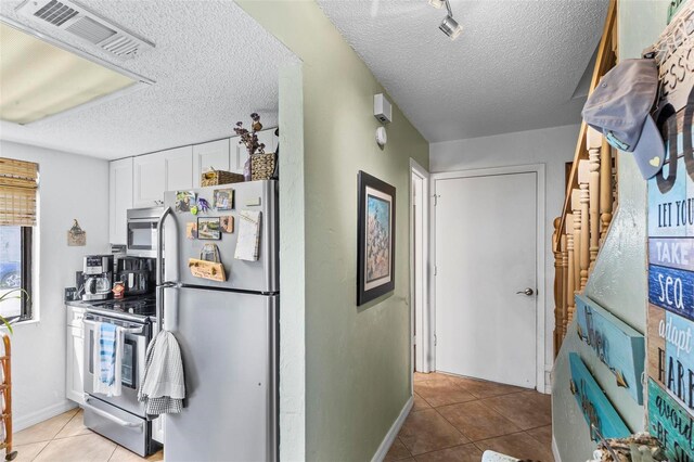 1601 N Ocean Shore Blvd, Flagler Beach, FL 32136 - corridor with light tile patterned floors, a textured ceiling, and baseboards
