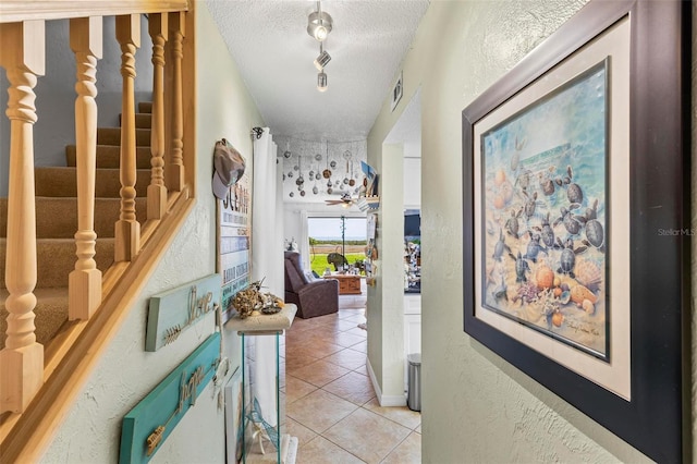 1601 N Ocean Shore Blvd, Flagler Beach, FL 32136 - hall featuring light tile patterned flooring, a textured ceiling, stairway, and a textured wall