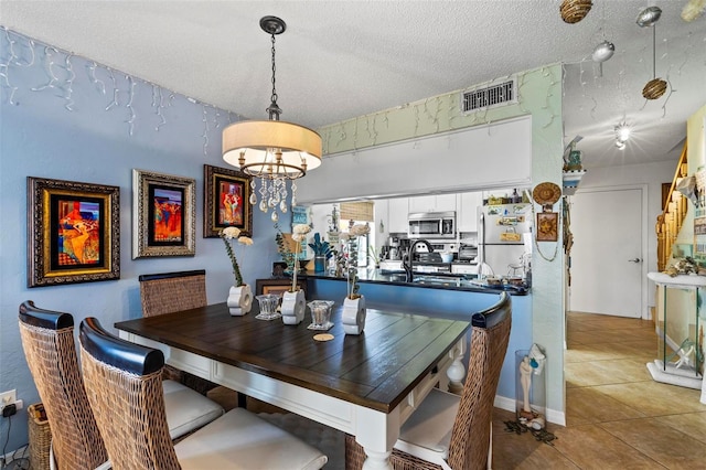 1601 N Ocean Shore Blvd, Flagler Beach, FL 32136 - tiled dining space featuring a textured ceiling and a chandelier