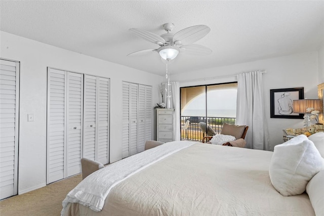1601 N Ocean Shore Blvd, Flagler Beach, FL 32136 - carpeted bedroom featuring access to exterior, two closets, a ceiling fan, and a textured ceiling