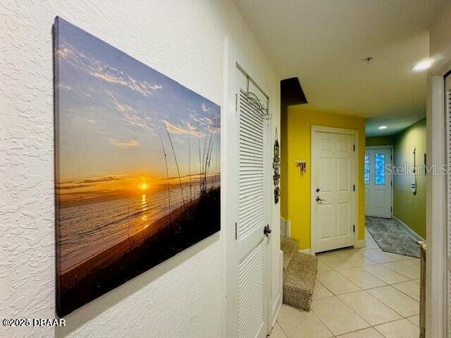 3000 Ocean Shore Blvd Unit 150, Ormond Beach, FL 32176 - corridor featuring baseboards and light tile patterned flooring