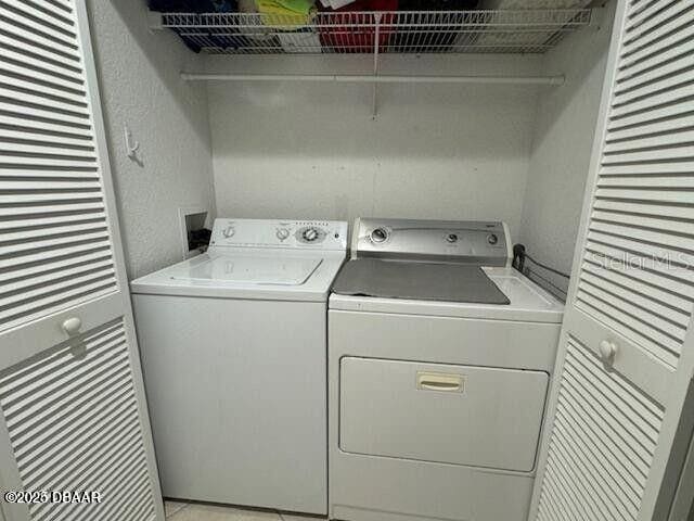 3000 Ocean Shore Blvd Unit 150, Ormond Beach, FL 32176 - laundry area with laundry area, independent washer and dryer, and a textured wall
