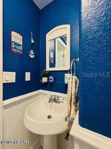 3000 Ocean Shore Blvd Unit 150, Ormond Beach, FL 32176 - bathroom featuring a sink and a wainscoted wall