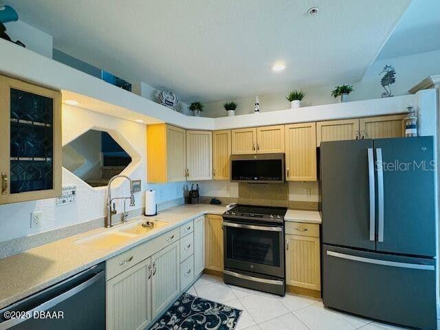 3000 Ocean Shore Blvd Unit 150, Ormond Beach, FL 32176 - kitchen with freestanding refrigerator, dishwasher, a sink, stainless steel microwave, and range with electric stovetop