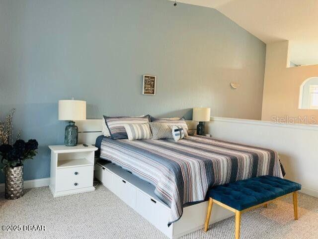 3000 Ocean Shore Blvd Unit 150, Ormond Beach, FL 32176 - bedroom featuring carpet, vaulted ceiling, and baseboards