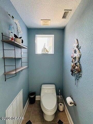 3000 Ocean Shore Blvd Unit 150, Ormond Beach, FL 32176 - bathroom with toilet, tile patterned flooring, visible vents, and a textured ceiling