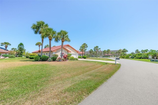 22 San Carlos Dr, Palm Coast, FL 32137 - view of front of property with driveway, an attached garage, and a front yard