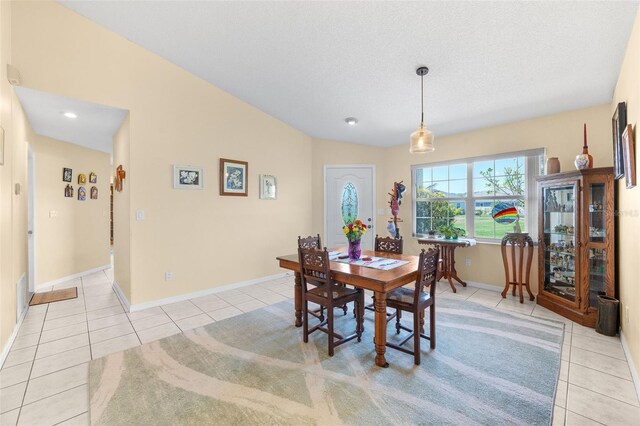 22 San Carlos Dr, Palm Coast, FL 32137 - dining space with light tile patterned floors, baseboards, and vaulted ceiling