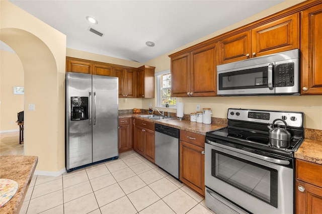 22 San Carlos Dr, Palm Coast, FL 32137 - kitchen with stainless steel appliances, a sink, arched walkways, brown cabinets, and recessed lighting