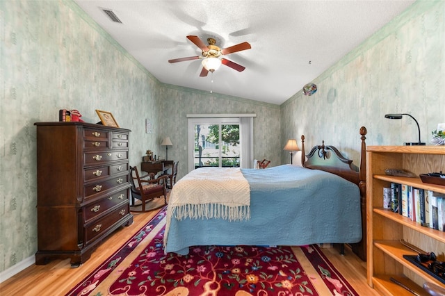22 San Carlos Dr, Palm Coast, FL 32137 - bedroom featuring wood finished floors, lofted ceiling, wallpapered walls, access to exterior, and ceiling fan