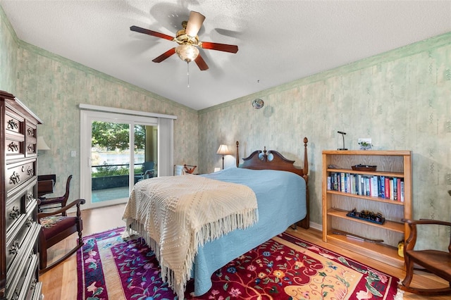 22 San Carlos Dr, Palm Coast, FL 32137 - bedroom with wood finished floors, vaulted ceiling, access to exterior, a textured ceiling, and ceiling fan