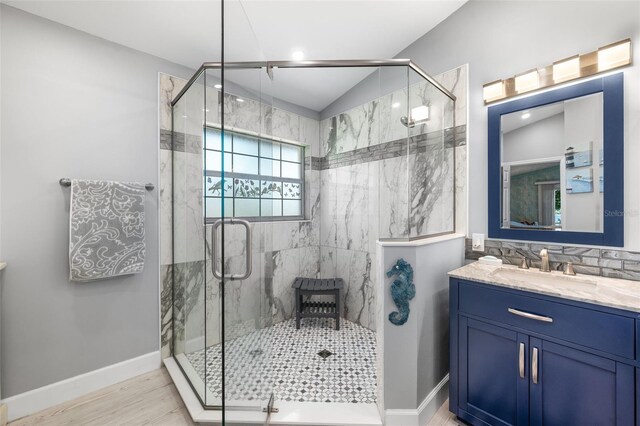 22 San Carlos Dr, Palm Coast, FL 32137 - full bath with a marble finish shower, vanity, wood finished floors, lofted ceiling, and baseboards
