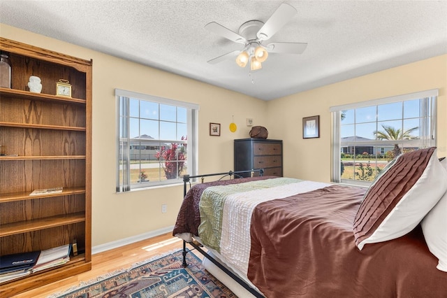 22 San Carlos Dr, Palm Coast, FL 32137 - bedroom featuring wood finished floors, baseboards, a textured ceiling, and a ceiling fan