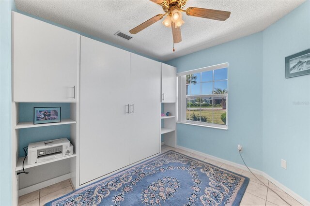 22 San Carlos Dr, Palm Coast, FL 32137 - unfurnished bedroom featuring a textured ceiling, light tile patterned flooring, and a ceiling fan
