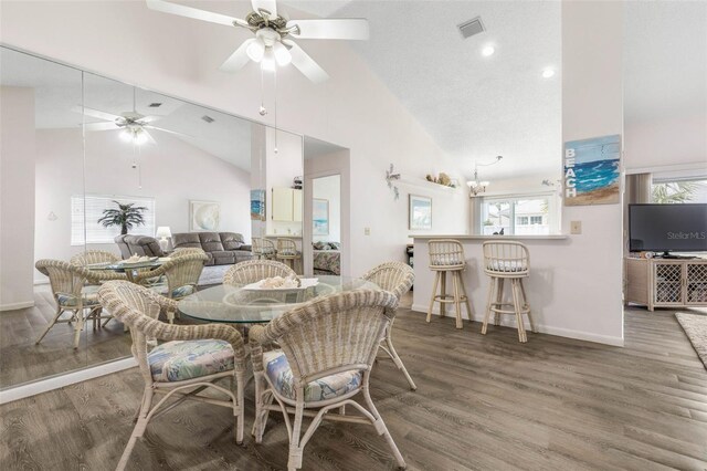 50 Nantucket Dr, Palm Coast, FL 32137 - dining area featuring high vaulted ceiling, baseboards, a ceiling fan, wood finished floors, and a chandelier