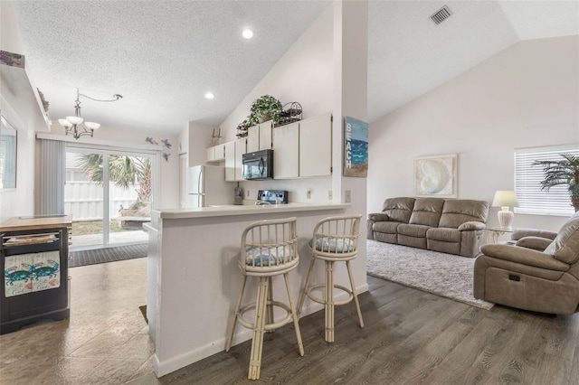 50 Nantucket Dr, Palm Coast, FL 32137 - kitchen featuring black microwave, freestanding refrigerator, dishwasher, a chandelier, and a peninsula