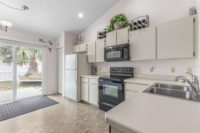 50 Nantucket Dr, Palm Coast, FL 32137 - kitchen with black appliances, a sink, a textured ceiling, vaulted ceiling, and light countertops