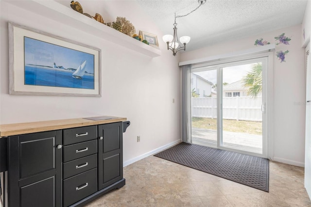 50 Nantucket Dr, Palm Coast, FL 32137 - doorway to outside with a chandelier, a textured ceiling, and baseboards