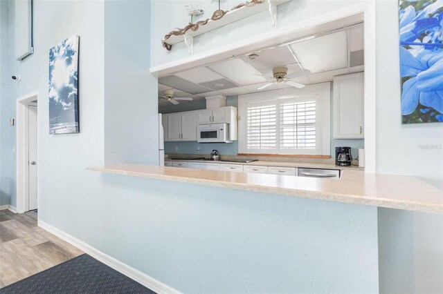 50 Nantucket Dr, Palm Coast, FL 32137 - kitchen featuring white microwave, ceiling fan, white cabinetry, stainless steel dishwasher, and light wood finished floors