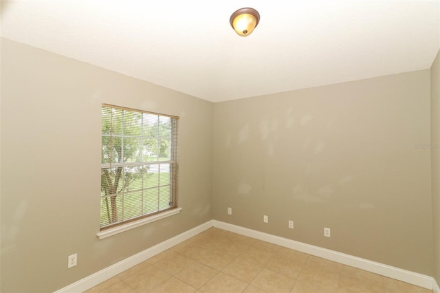 unfurnished room with light tile patterned flooring and baseboards
