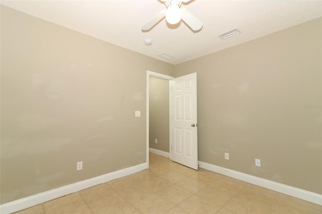 unfurnished room with light tile patterned floors, visible vents, baseboards, and a ceiling fan