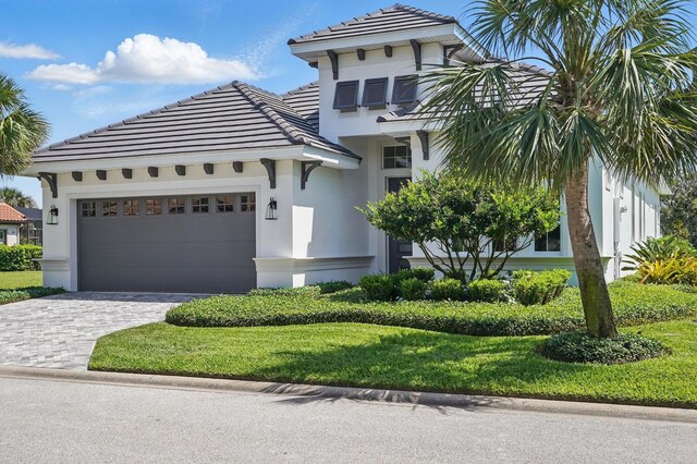 17 Kingfisher Ln, Palm Coast, FL 32137 - mediterranean / spanish-style home featuring a tiled roof, an attached garage, stucco siding, and decorative driveway