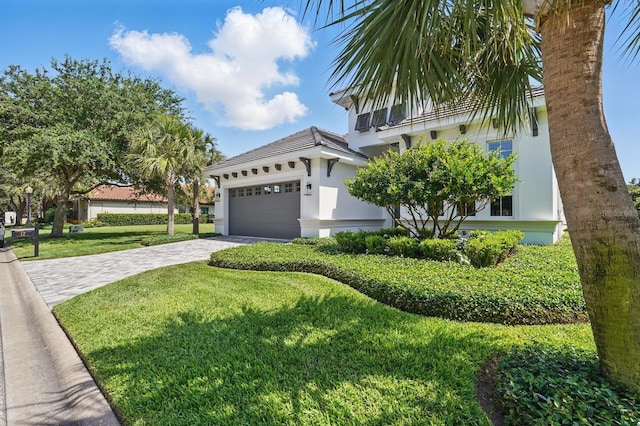 17 Kingfisher Ln, Palm Coast, FL 32137 - view of front of house with stucco siding, decorative driveway, a front yard, and a garage