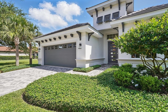 17 Kingfisher Ln, Palm Coast, FL 32137 - view of front of home with stucco siding, decorative driveway, an attached garage, and a front yard