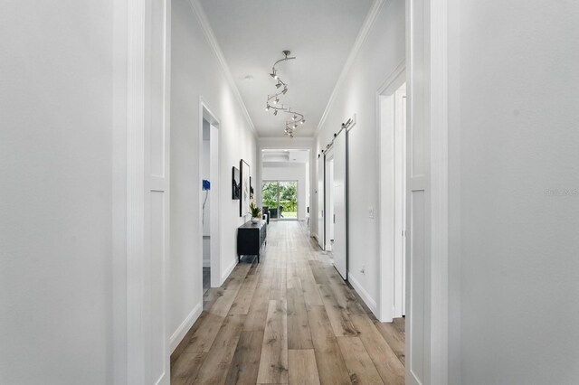 17 Kingfisher Ln, Palm Coast, FL 32137 - hallway featuring ornamental molding, light wood-type flooring, baseboards, and a barn door