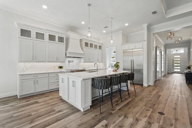 17 Kingfisher Ln, Palm Coast, FL 32137 - kitchen featuring built in refrigerator, custom range hood, crown molding, a sink, and white cabinets