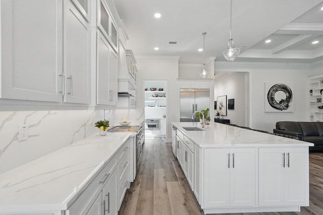 17 Kingfisher Ln, Palm Coast, FL 32137 - kitchen featuring appliances with stainless steel finishes, a sink, light wood-type flooring, a spacious island, and white cabinetry