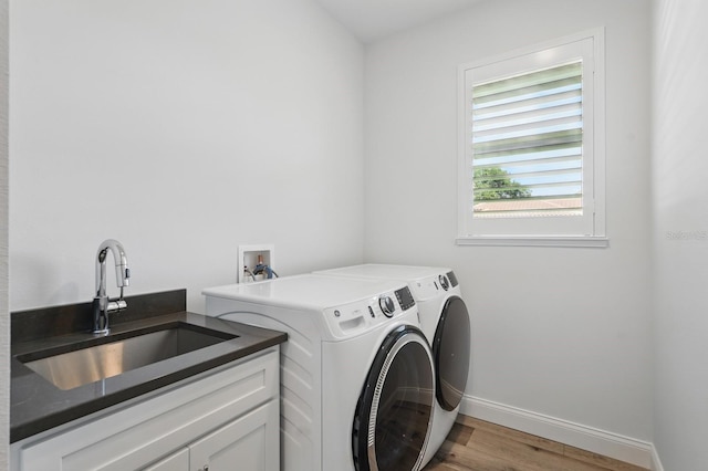 17 Kingfisher Ln, Palm Coast, FL 32137 - washroom with washing machine and clothes dryer, light wood finished floors, baseboards, and cabinet space