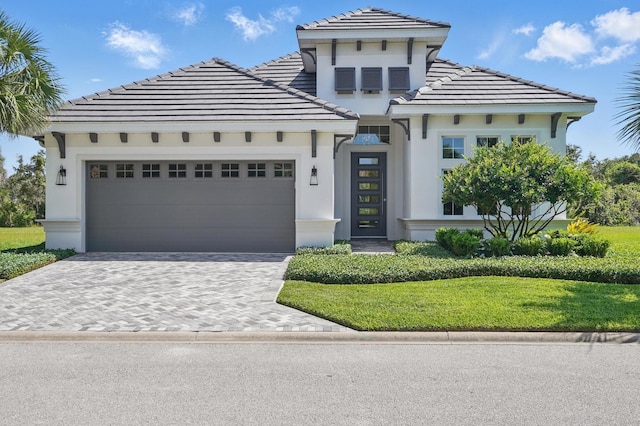 17 Kingfisher Ln, Palm Coast, FL 32137 - view of front facade featuring an attached garage, a tiled roof, stucco siding, and driveway