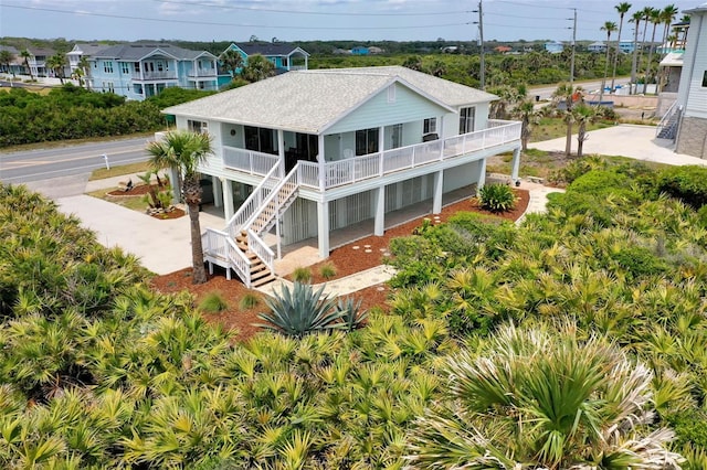 6973 N Oceanshore Blvd, Palm Coast, FL 32137 - back of property featuring roof with shingles, stairway, and covered porch