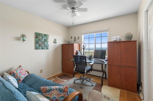 6973 N Oceanshore Blvd, Palm Coast, FL 32137 - office featuring wood finished floors, a ceiling fan, a textured ceiling, and baseboards